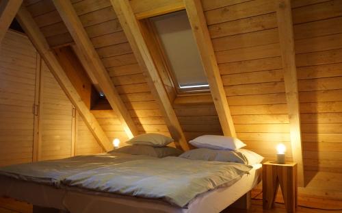 a bed in a wooden room with a window at Ferienhaus am Schönbuchrand in Herrenberg