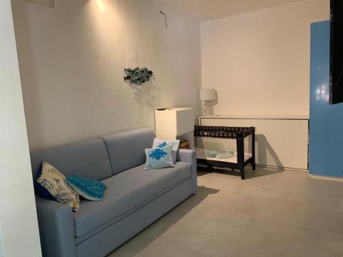 a living room with a blue couch and a table at Free Beach Holiday Home in Monte Nai