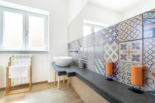 a bathroom with a sink and tiles on the wall at Teatro Massimo City Center Apartments in Palermo