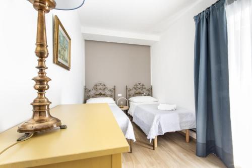 a room with two beds and a table with a lamp at Teatro Massimo City Center Apartments in Palermo
