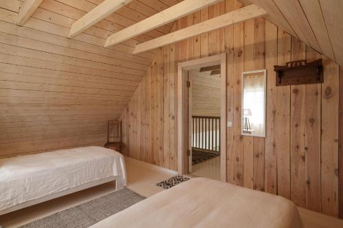 a room with two beds in a wooden cabin at Villa Bumba in Liigalaskma