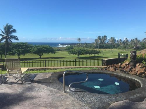 uma banheira de hidromassagem num quintal com um campo de golfe em Mauna Kai'iki em Pahala
