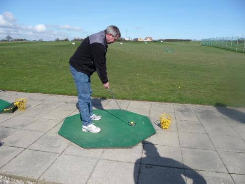 a man playing golf on a putting green at Stor lejlighed midt i Sønderborg by. in Sønderborg