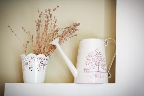 two white vases sitting on a shelf with flowers at Avto Spa in Khmelʼnytsʼkyy