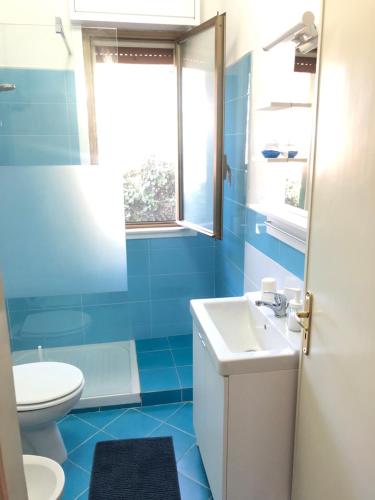 ein blaues Bad mit einem Waschbecken und einem WC in der Unterkunft Villa Violetta in Carini