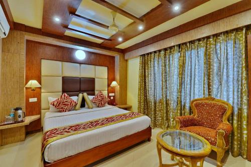 1 dormitorio con 1 cama extragrande y 1 silla en Hotel Sidharth en Bhubaneshwar