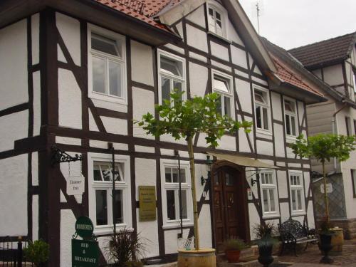 a black and white house with a tree in front of it at Robert's Bed & Breakfast in Helmarshausen