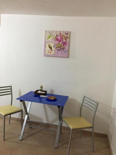 a blue table with two chairs and a picture on the wall at La tua casa a Matera in Matera
