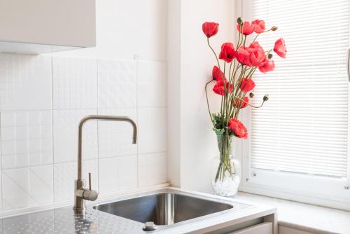 a vase of red flowers sitting on a kitchen counter at Cinque Terre Bridge in La Spezia