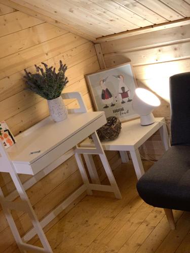 a room with a table and a lamp and a chair at Fjordcottage in Søldarfjørður