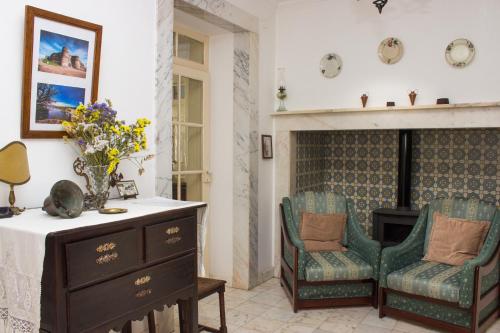 a living room with two chairs and a table and a fireplace at Casa dos Tios Estremoz-veiros in Veiros