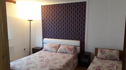 a bedroom with a bed and a purple wall at Apartments Alibasic in Dubrave Gornje