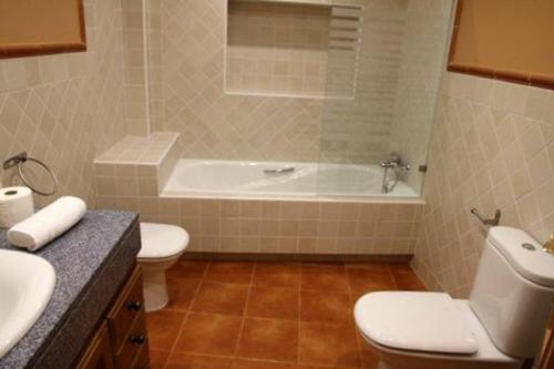 a bathroom with a tub and a toilet and a sink at Martin Gamero Apartments in Toledo