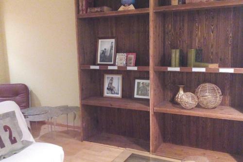 a wooden book shelf with pictures and vases on it at Martin Gamero Apartments in Toledo