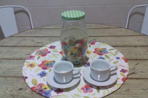 a table with two cups and a jar of candy at Martin Gamero Apartments in Toledo