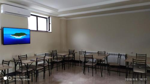a room with tables and chairs and a flat screen tv at ASOUR HOTEL in Goris