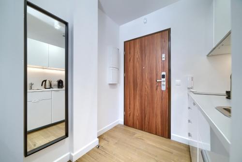 una cucina con porta in legno in una camera di Apple Park a Poznań