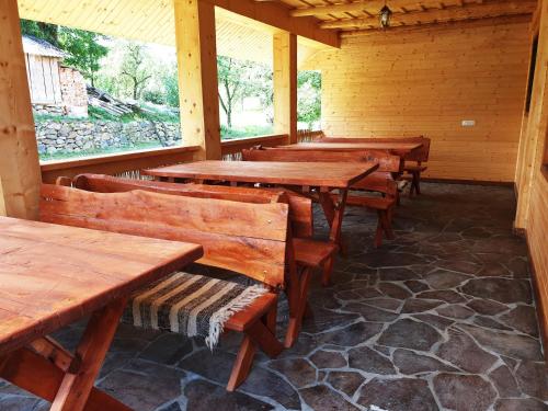 a row of wooden tables and benches in a cabin at Popas in Breb in Breb