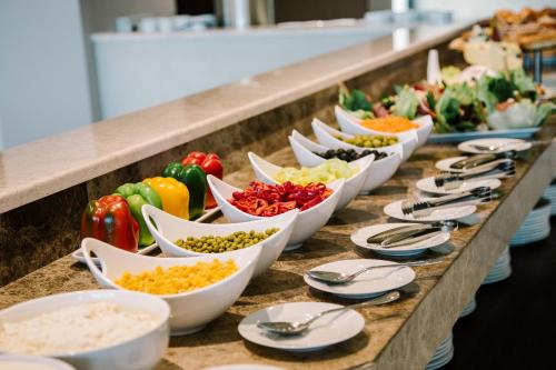 a buffet line with bowls of different types of vegetables at Hotel Tbilisi Tower in Tbilisi City