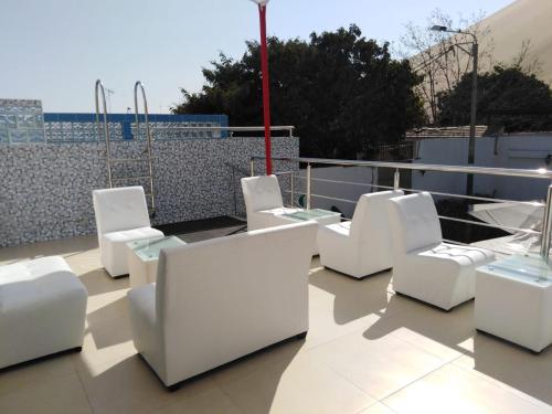 a group of white chairs and tables on a roof at Hotel Santa Maria in Ica