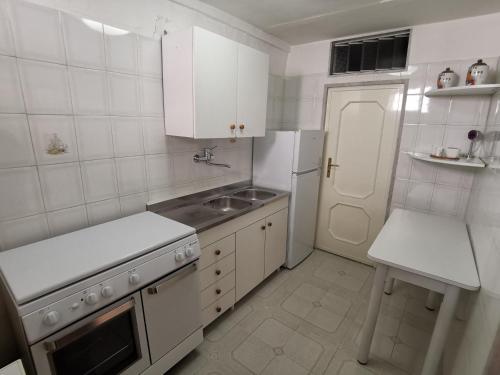 a white kitchen with a sink and a refrigerator at La Sannal casa vacanze in Minervino Murge