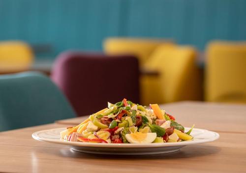 a plate with a salad on a table at Hotel Nais in Niš