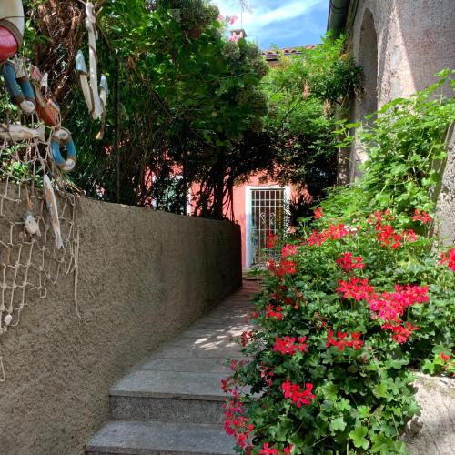 a garden with red flowers next to a building at Il Giardino Segreto Arona, Charming Apartments in Arona