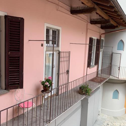 a pink building with a balcony with flowers on it at Il Giardino Segreto Arona, Charming Apartments in Arona