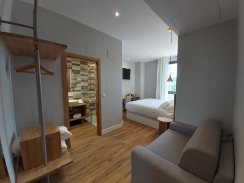 a bedroom with a bed and a couch in a room at Habital Suites in Jaca