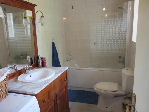 een badkamer met een wastafel, een bad en een toilet bij Caurelgranges in Caurel