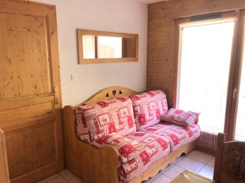 a couch sitting in a room with a window at balcon des pistes in Les Deux Alpes