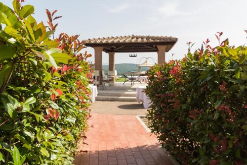 a brick walkway with bushes and a gazebo at Agriturismo Il Felciaione in Massa Marittima