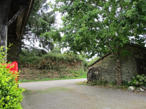 a stone building with a wheel next to a road at Caurelgranges in Caurel