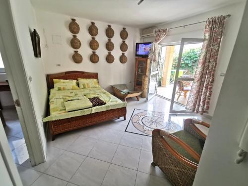 a bedroom with a bed and a tv on a wall at Apartments Rales in Sveti Stefan