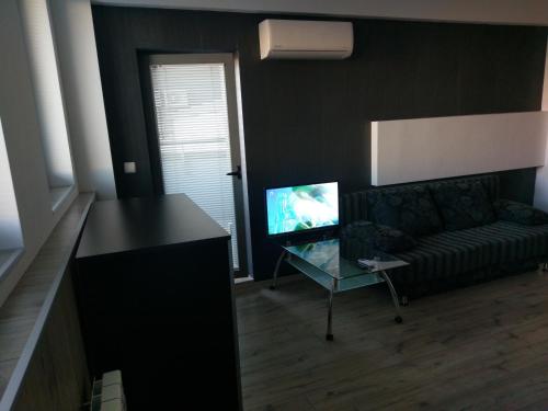 ein Wohnzimmer mit einem Sofa und einem Glastisch in der Unterkunft City apart in Sofia
