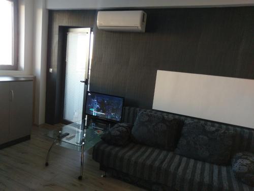a living room with a couch and a tv at City apart in Sofia