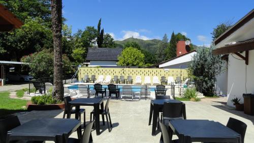 un patio con mesas y sillas y una piscina en Posada Ojo de Agua Villa General Belgrano en Villa General Belgrano