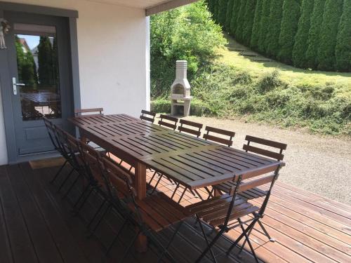 a wooden table and chairs on a deck with a bottle of wine at Le Clos Des Mynes in Le Thillot