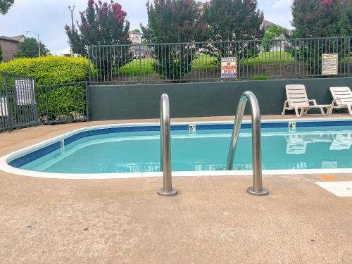 a swimming pool with metal rails next to a fence at Green Gables Inn in Branson