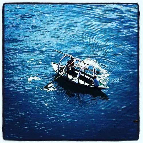 two people in a small boat in the water at B&B Villa Anita in Bellano