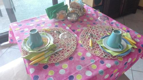 a pink polka dot table with plates and utensils at B&B Villa Anita in Bellano