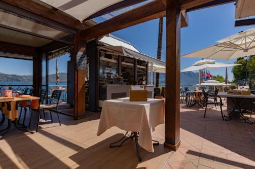 a patio with tables and umbrellas on the water at Residence Casa e Vela in Oggebbio