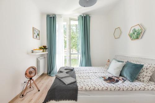 a bedroom with a bed with blue curtains and a window at SuperApart Gagarina MiniStudio in Warsaw