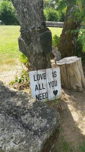 a sign that says love is all you need next to a tree at Casa Valxisto in Penafiel