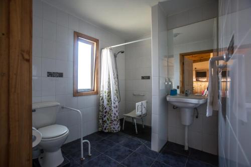 a bathroom with a toilet and a sink at Cabañas Piedra Grande in Pichilemu
