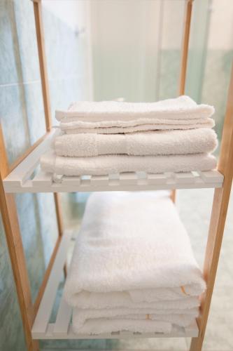 a stack of white towels on a shelf at B&B CA DEL SOLE in Serravalle Scrivia