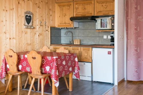 een keuken met een tafel met een rode tafellaken bij Appartement de iina aux 2 Alpes 1650 m - 4 pers in Les Deux Alpes