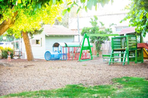 a playground with a slide and a swing at Etzel Tami Hospitality in Neot Golan