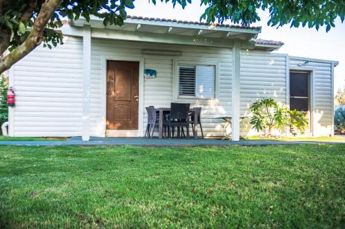 a white house with a table and chairs in a yard at Etzel Tami Hospitality in Neot Golan