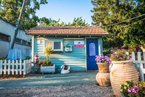 a tiny house with a blue door and some flowers at Etzel Tami Hospitality in Neot Golan